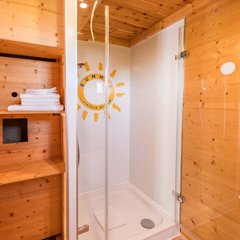Dusche mit Regal nebenan mit Handtüchern