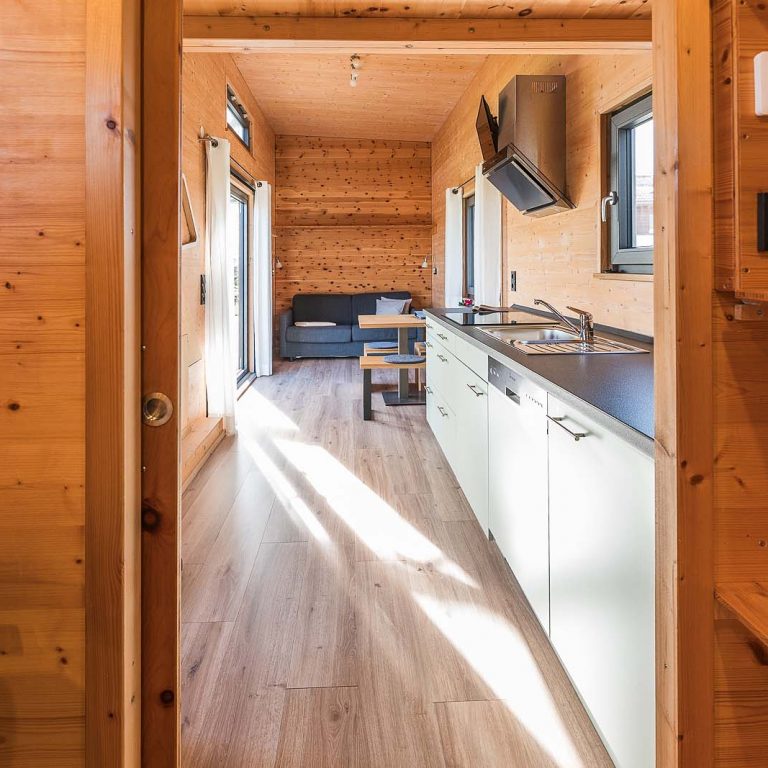 Blick aus dem Badezimmer in den Wohn- und Essbereich im Tiny House