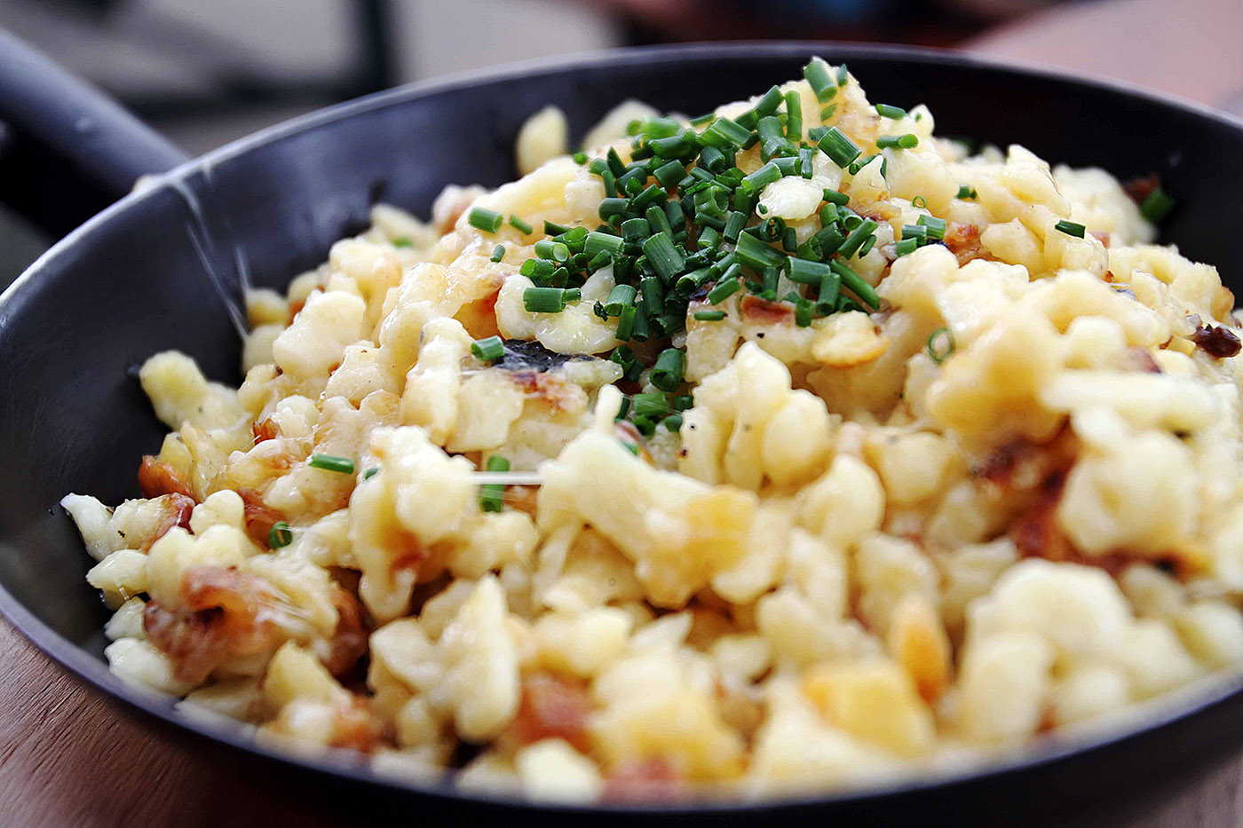Pfanne mit Käsespätzle und Schnittlauch darüber