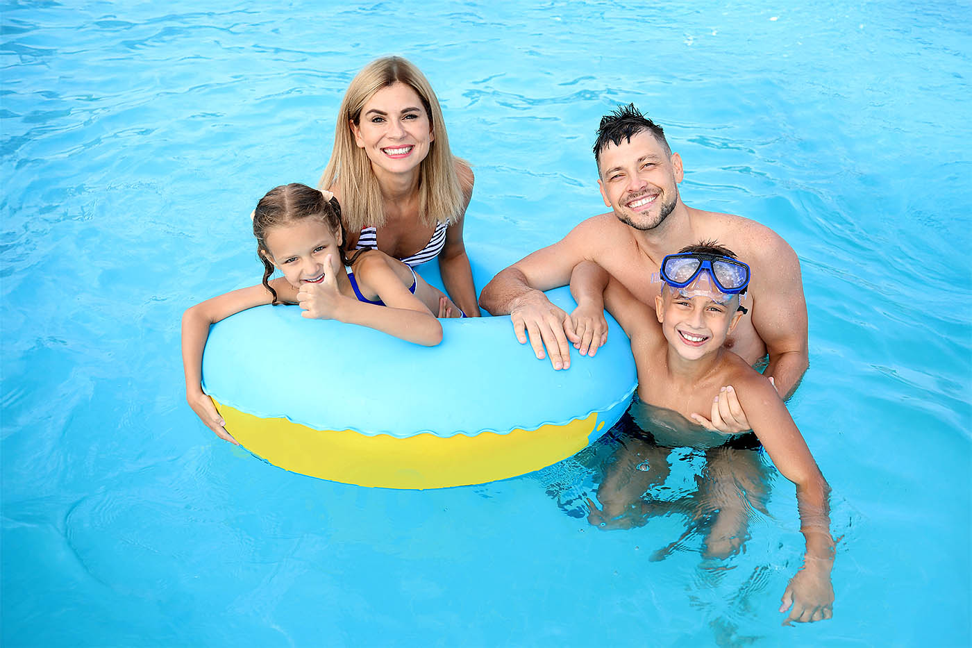 Familie mit Schwimmring im Schwimmbad