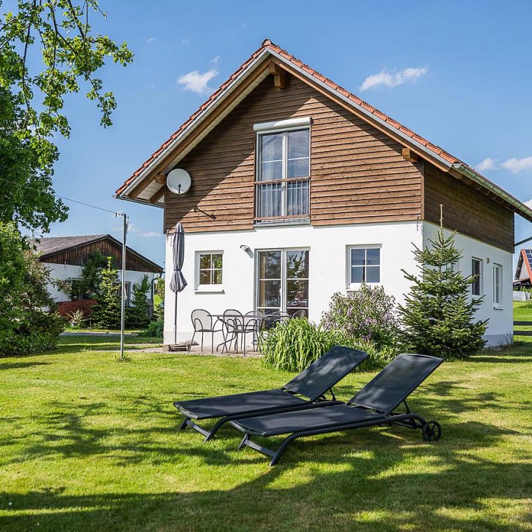 Haus von außen mit Blick auf die Terrasse und Liegestühlen im Vordergrund
