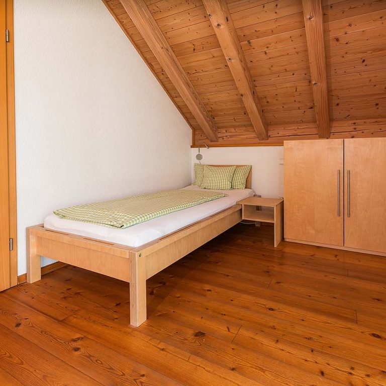 Einzelbett mit Schrank daneben