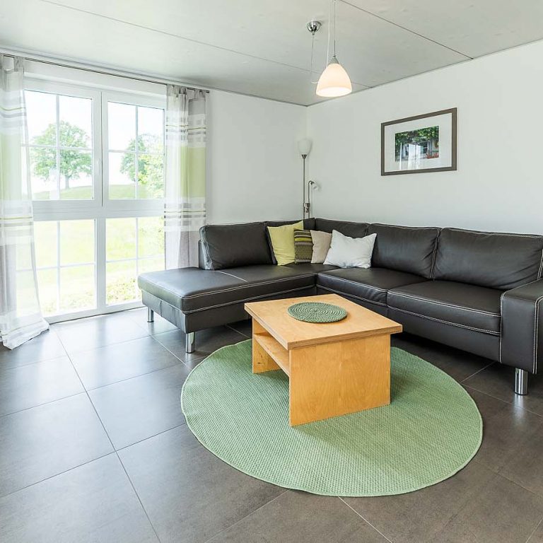 Sofa mit großer Tür mit Blick ins Grüne