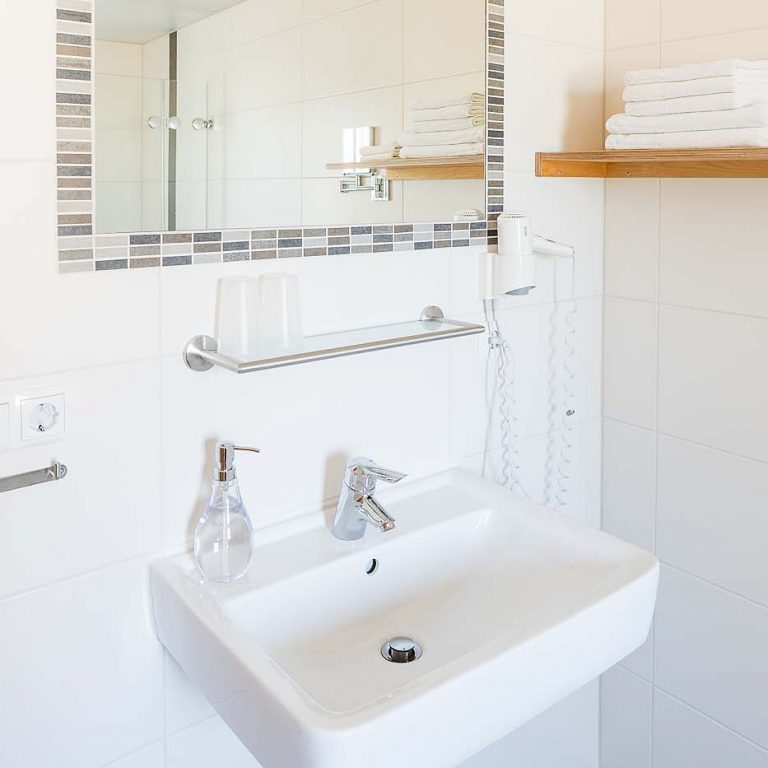 Badezimmer mit Spiegel und Waschbecken
