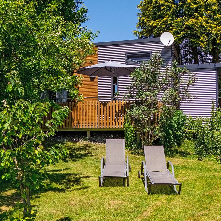 Tiny House mit Liegestühlen im Garten